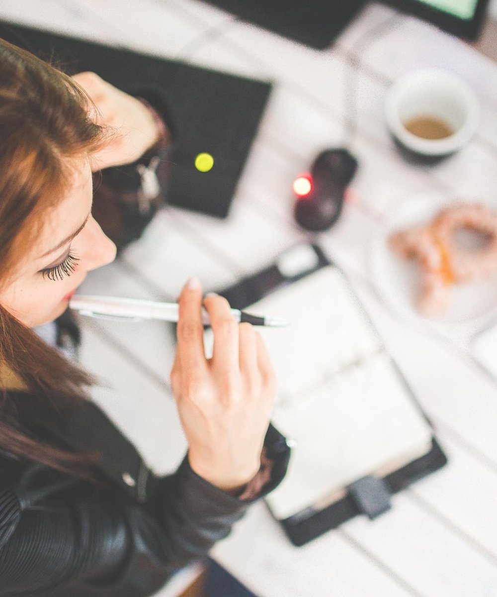 Profissional de assessoria acadêmica escrevendo com foco e dedicação